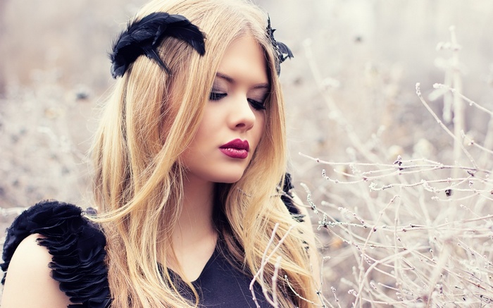 Woman with black feathers and blonde hair