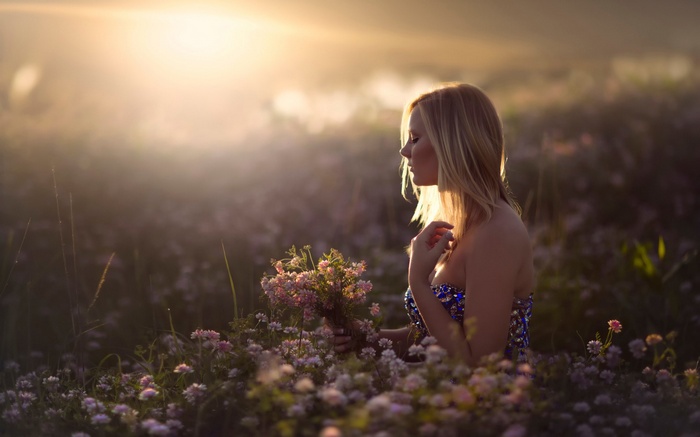 Woman in a field of flowers at sunset