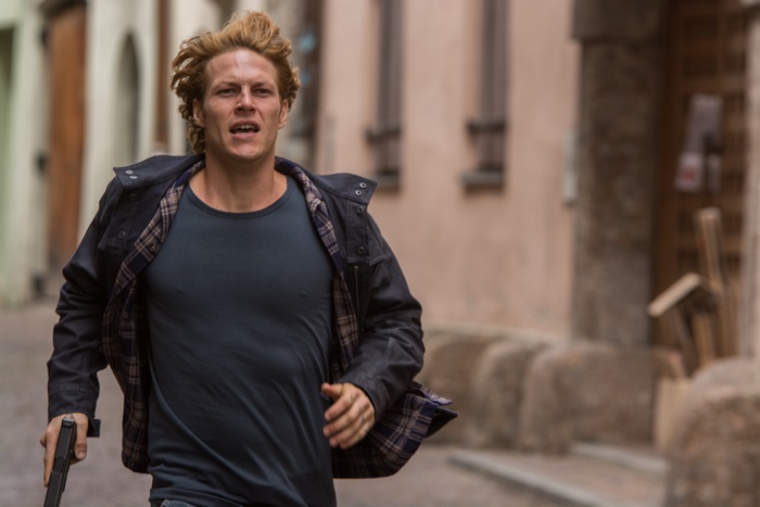 Luke Bracey running with a gun