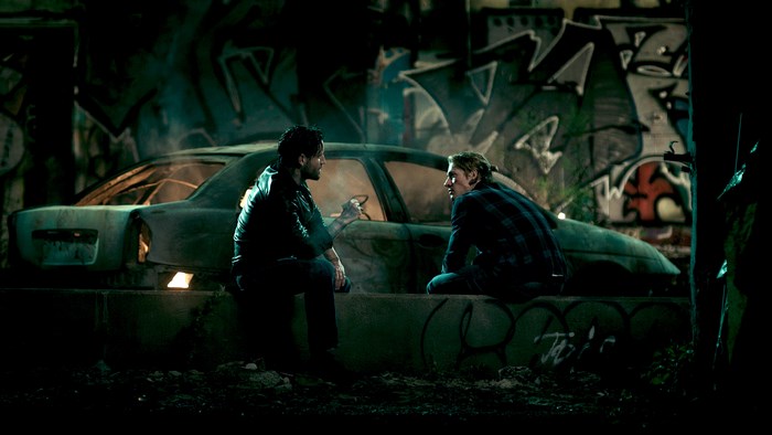 Luke Bracey in front of graffiti and a car