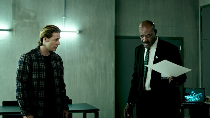 Luke Bracey and man in suit with papers