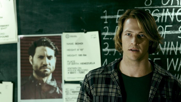 Luke Bracey in front of a bulletin board
