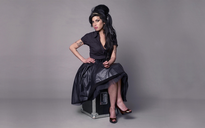 Amy Winehouse sitting on a case