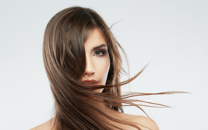 Woman with long brown hair blowing in the wind