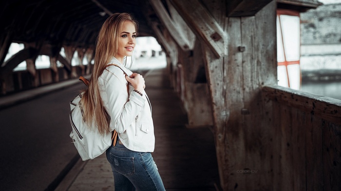 Woman with backpack on wooden bridge