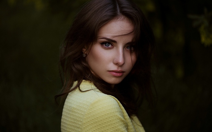 Woman in yellow jacket looking at camera