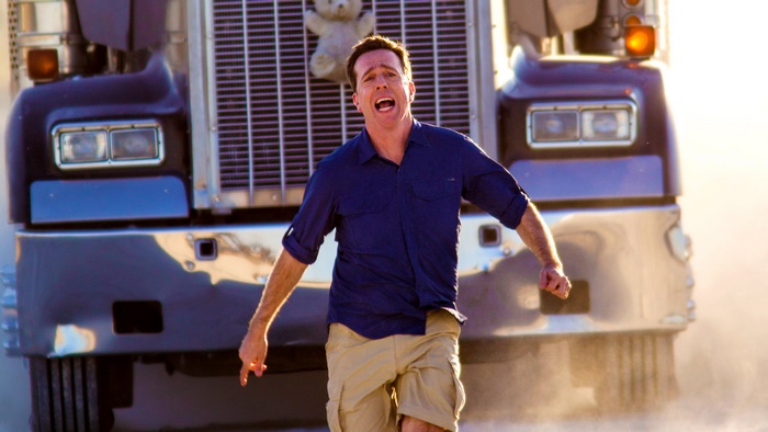 Ed Helms running from a truck