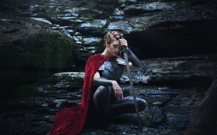 Woman in armor with sword in forest