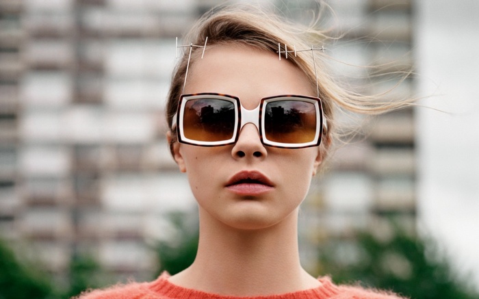 Woman with large sunglasses and avant-garde headpiece