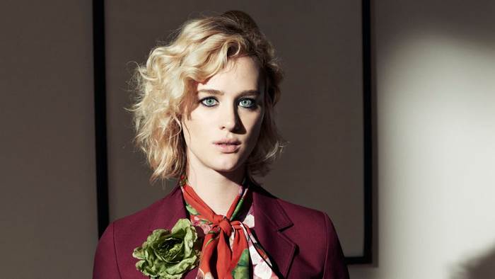 Mackenzie Davis in a maroon blazer with a floral scarf