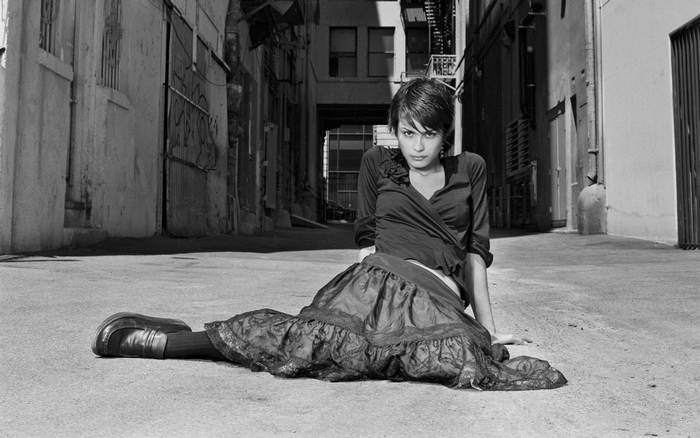 Shannyn Sossamon sitting in an alley