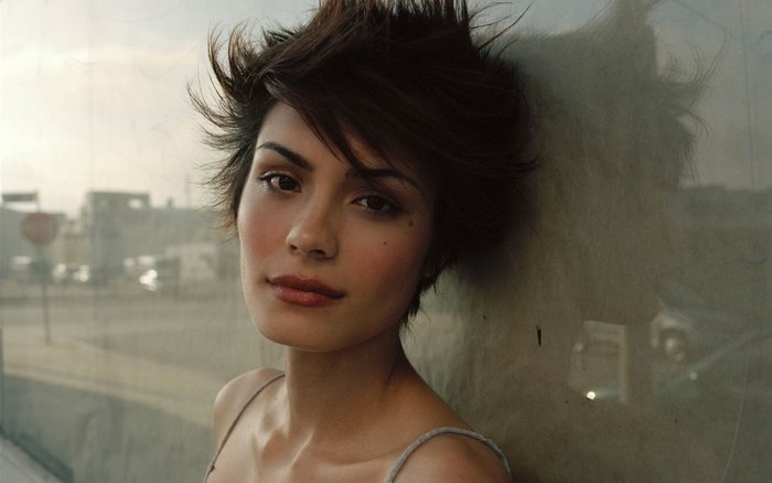 Shannyn Sossamon leaning against a wall