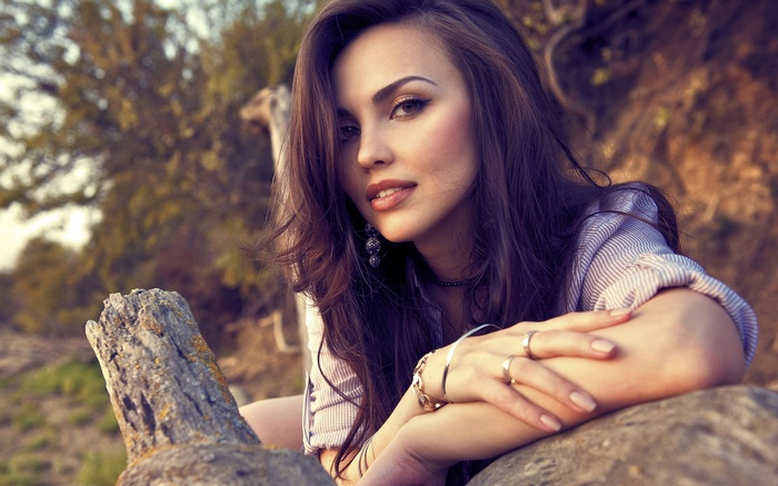 Woman leaning on a rock outdoors