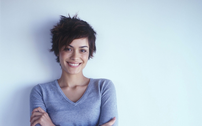 Shannyn Sossamon smiling with arms crossed