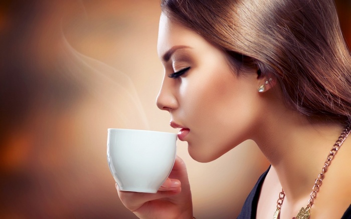 Woman drinking coffee with steam