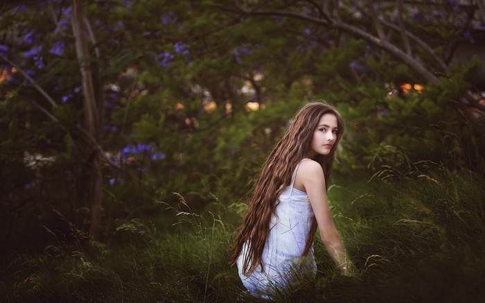 Young girl with long hair in a grassy field
