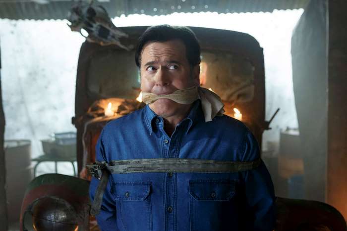 Bruce Campbell tied up in front of a car