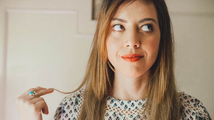 Woman with orange lipstick and turquoise ring