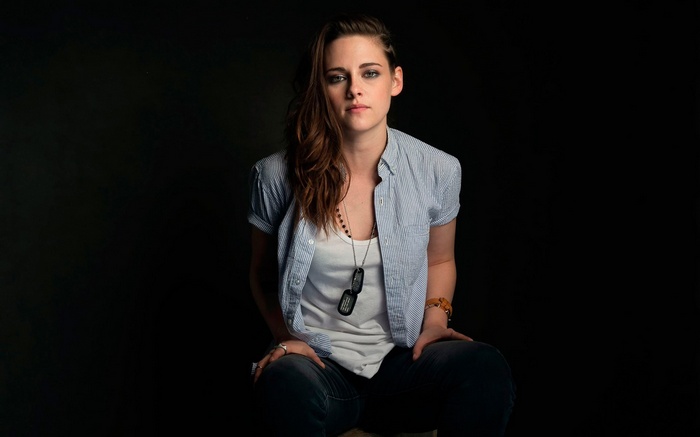 Kristen Stewart sitting against a black background