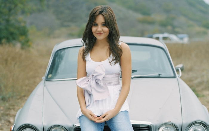 Amanda Bynes sitting on a car