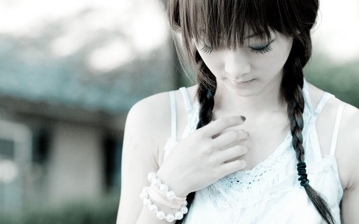 Young woman with braided hair wearing a pearl bracelet