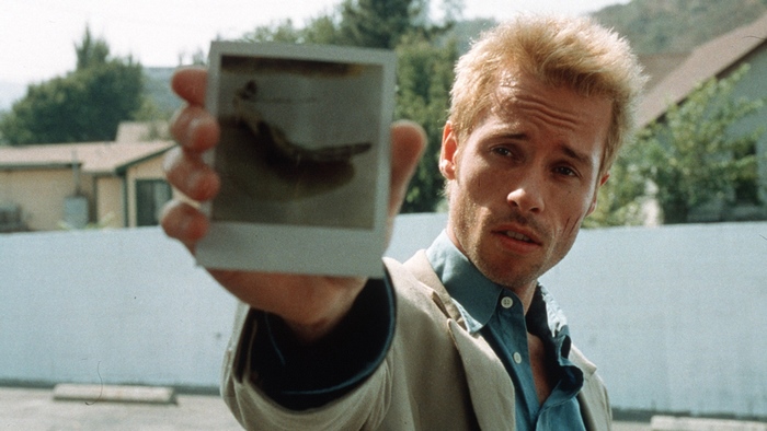 Guy Pearce holding a polaroid photo