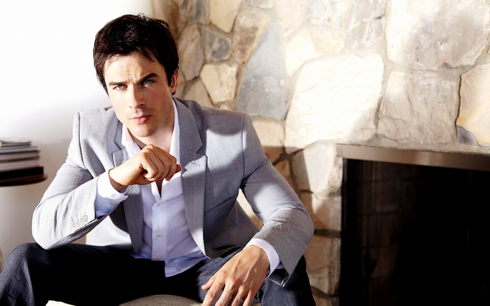 Ian Somerhalder sitting in front of a stone fireplace