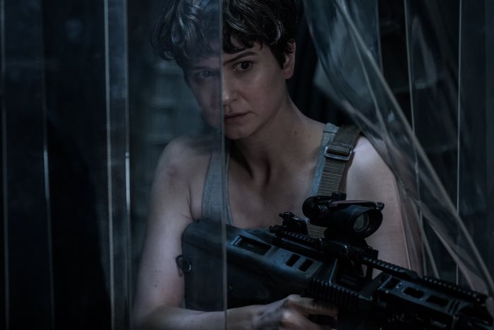 Katherine Waterston holding a rifle