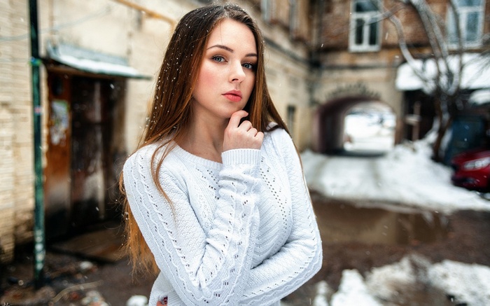 Young woman in a white sweater in winter