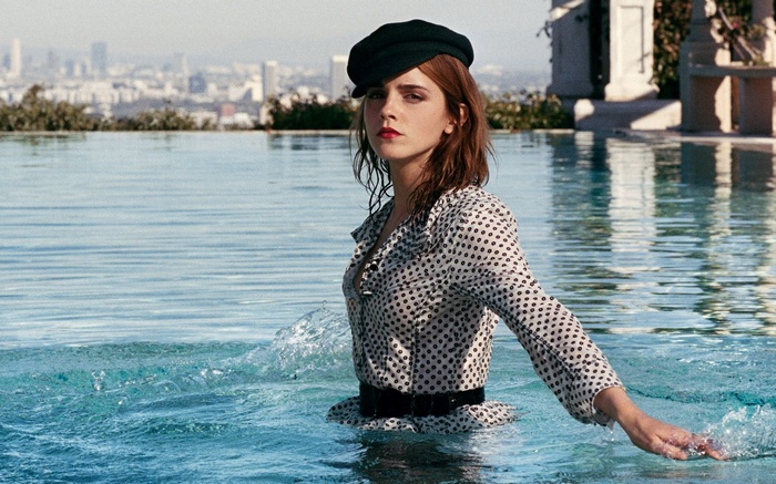 Emma Watson in a swimming pool with city in background