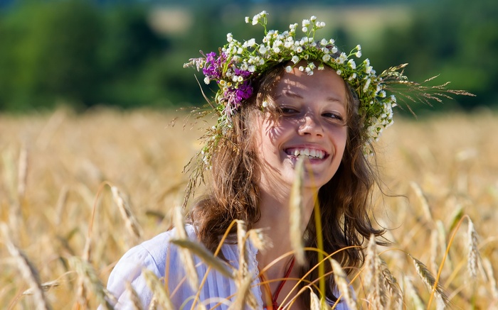 Woman with flower crown in wheat field