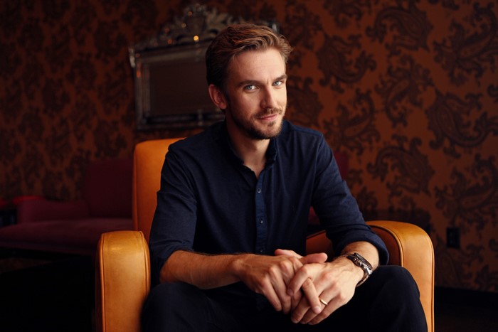 Dan Stevens sitting in an armchair