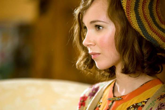 Juno Temple in a colorful outfit and hat