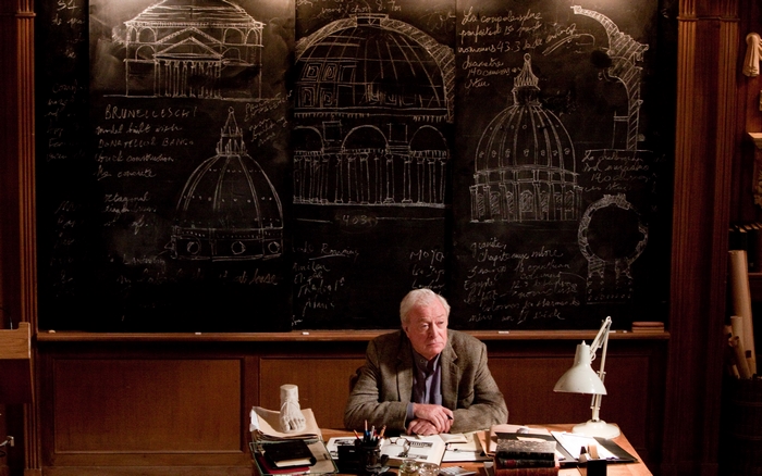 Michael Caine in front of architectural drawings