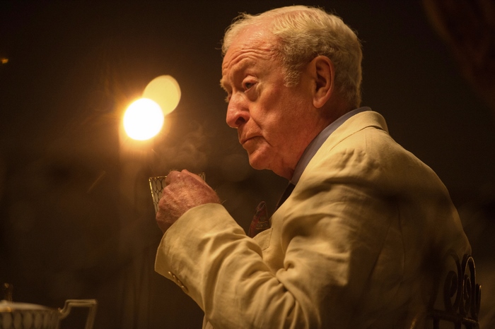 Michael Caine holding a glass