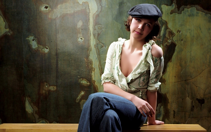 Maggie Gyllenhaal sitting on a bench