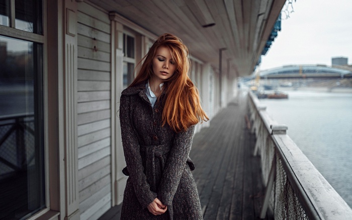 Woman with red hair on a pier