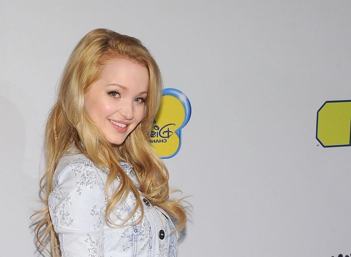 Smiling Dove Cameron with Long Blonde Hair in Light Jacket