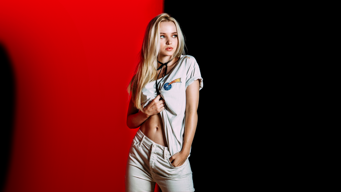 Dove Cameron posing against a red and black background