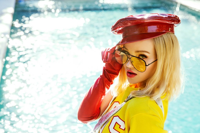 Dove Cameron in red hat and yellow shirt