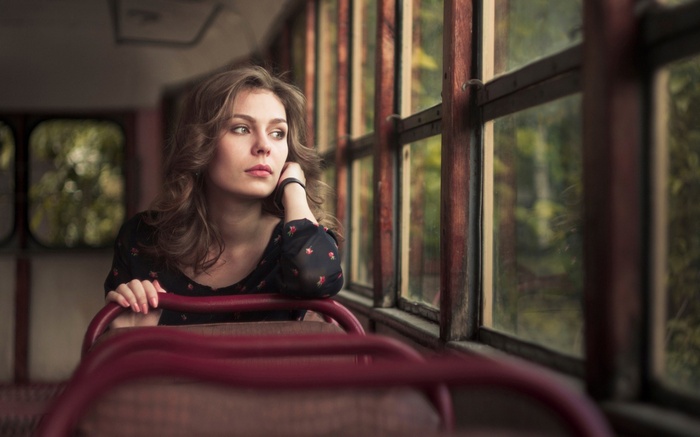 Young woman looking out a bus window