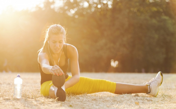 Woman stretching outdoors at sunset