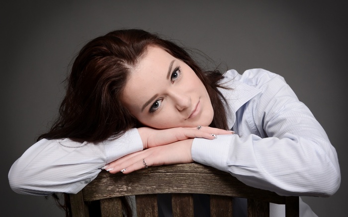 Woman resting her head on her arms on a chair
