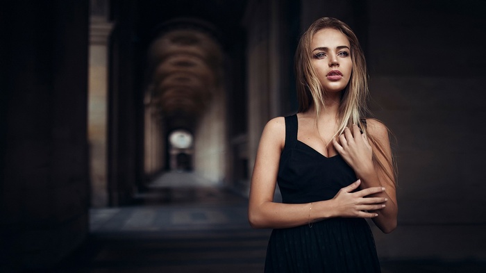 Woman in black dress in a dark hallway