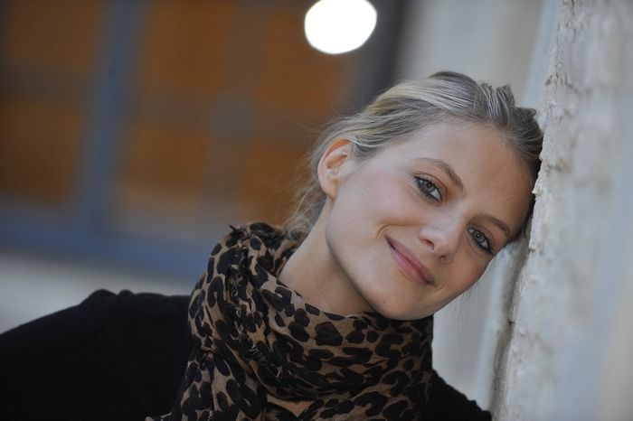 Mélanie Laurent leaning against a wall