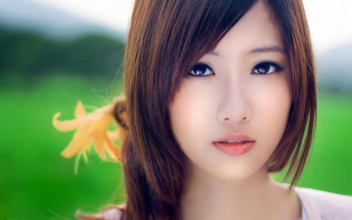 Close-up of a young woman with a flower in her hair