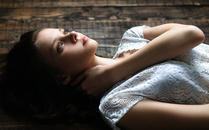 Woman lying on wooden floor