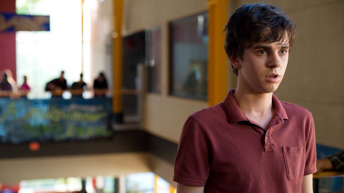 Freddie Highmore in a maroon polo shirt