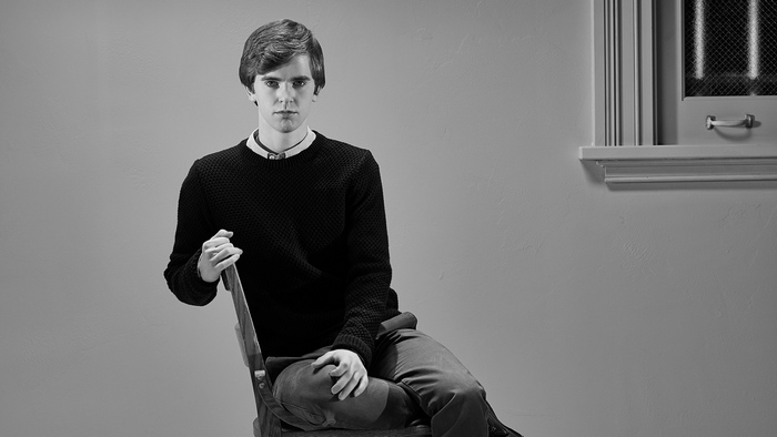 Freddie Highmore sitting on a chair