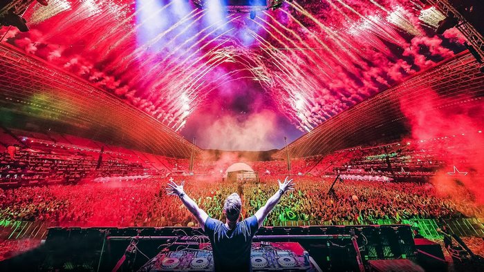 DJ Hardwell performs for a large crowd with fireworks